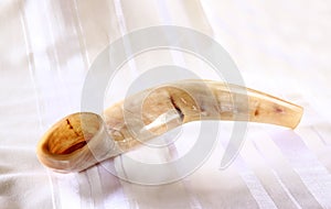 Shofar (horn) on white prayer talit. room for text. rosh hashanah (jewish holiday) concept . traditional holiday symbol.