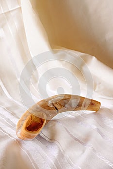 Shofar (horn) on white prayer talit. room for text. rosh hashanah (jewish holiday) concept . traditional holiday symbol.