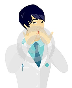 Shoked asian doctor covering his mouth. photo