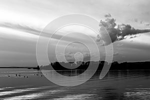 A shoot of a sunset over a lake, with perfectly symmetric clouds reflections on water