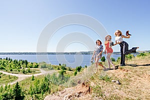 Shoot of three beautiful girls outdoors by the river. Female friends relaxing by the river and smiling. Girlfriends are