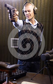 Shooter practicing sport handgun shooting at firing range
