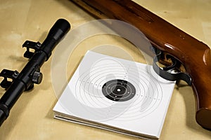 Shooting accessories on a wooden table in a shooting range. Shield and projectiles for pneumatic weapons before shooting.