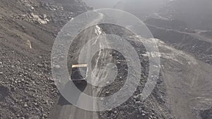 Shooting from the air. In a quarry, a BelAZ rides full of iron ore.