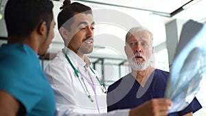 Shooting from below of happy team of dedicated multi-ethnic of professional doctors talking.