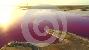 Shooting from a drone flying over a pink salt flat with a calm water surface. Syvash Lake, Ukraine, Europe