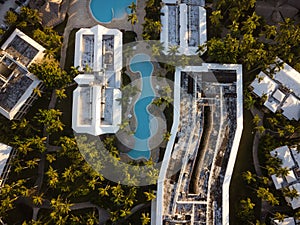 Shooting from a drone. Palm trees, swimming pools, roofs of tall buildings and small houses. Hotels, resort place. Paradise place