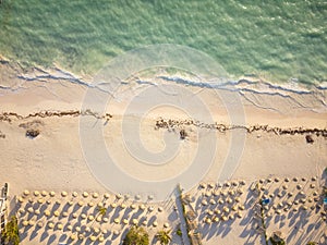 Shooting from a drone. Sea coast. Clear turquoise water with light white waves crashes onto a white sandy beach. There are many
