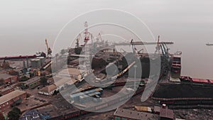 Shooting from a drone of a seaport with cranes and tankers for transporting coal and oil