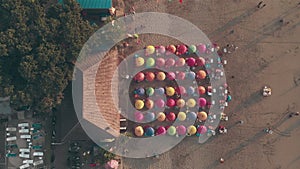 Shooting from drone - vacationers on the beach. Aerial view of People spending their leisure time on the beach, sitting