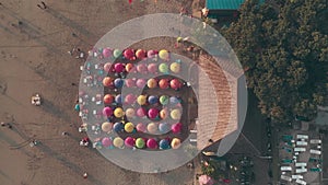 Shooting from drone - vacationers on the beach. Aerial view of People spending their leisure time on the beach, sitting