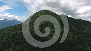 Shooting from a drone in the wild highlands. The approach to the mountain is covered with forest