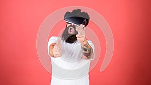 Shooting gallery VR. Man bearded hipster with virtual reality headset on red background. First person shooter shows how