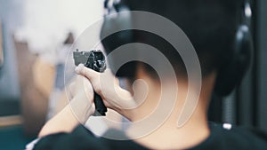 Shooting gallery. A young man aiming in a target using a gun. Shooting