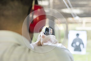 Shooting with Gun at Target in Shooting Range. Man Practicing Fire Pistol Shooting. photo