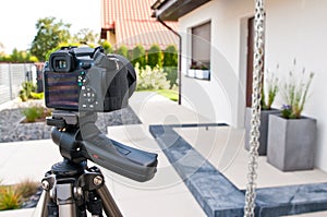 Shooting house exterior, photographer camera, tripod and ballhead