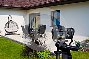 Shooting house exterior, photographer camera, tripod and ballhead