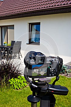 Shooting house exterior, photographer camera, tripod and ballhead photo