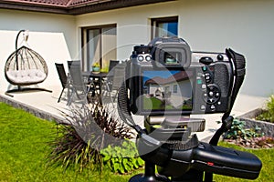 Shooting house exterior, photographer camera, tripod and ballhead photo