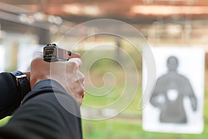 Shooting with a pistol. Man aiming pistol in shooting range. photo