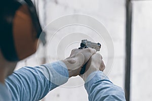 Shooting with a pistol. Man aiming pistol in shooting range.