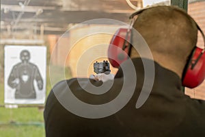 Shooting with a pistol. Man Firing pistol in shooting range.