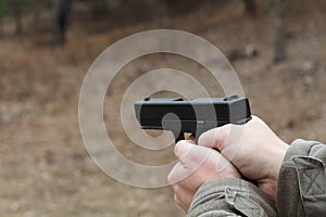 Shooting from a pistol. Reloading the gun. The man is aiming at the target. Shooting range. Man firing usp pistol at target in ind