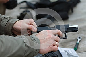 Shooting from a pistol. Reloading the gun. The man is aiming at the target. Shooting range. Man firing usp pistol at target in ind