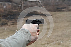 Shooting from a pistol. Reloading the gun. The man is aiming at the target. Shooting range. Man firing usp pistol at target in ind