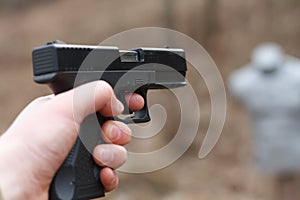 Shooting from a pistol. Reloading the gun. The man is aiming at the target. Shooting range. Man firing usp pistol at target in ind