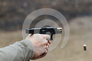 Shooting from a pistol. Reloading the gun. The man is aiming at the target. Shooting range. Man firing usp pistol at target in out