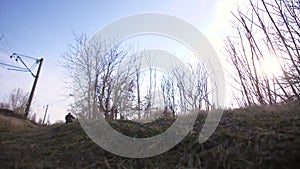 Shooting young bicker on vintage motorcycle crossing field road