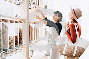 Shop assistant helping customer in bulk food store