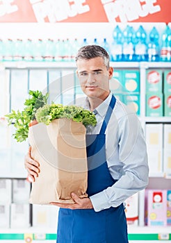 Shop assistant holding a grocery bag