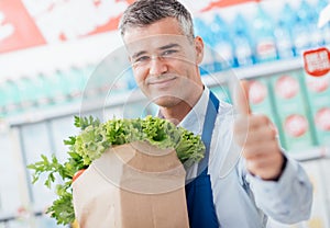 Shop assistant holding a grocery bag