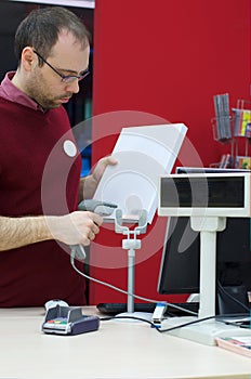 Shop assistant male scanning a book