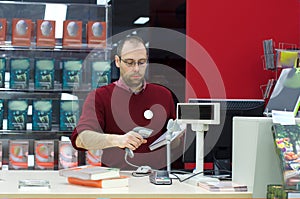 Shop assistant male scanning a book