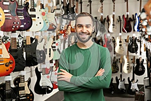 Shop assistant near guitars in music store