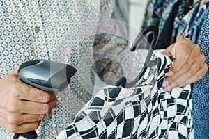 shop assistant scanning a barcode in a clothes shop using
