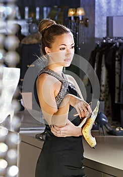 Shop assistant with shoe in a boutique