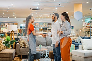 Shop assistants shake hands with customers when buying a sofa