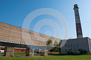 Shop blacksmithing plant. Huge chimney of an industrial plant that produces. against the blue sky