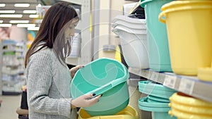 Shop of goods for home. A young woman chooses a large plastic pelvis