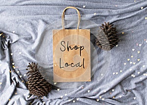 `Shop Local` text on a plain brown paper bag flat lay