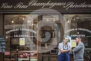 Shop seller standing in front of a traiteur, a traditional parisian caterer selling french dishes and gastronomy to go