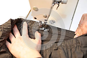 Shop for tailoring. A woman creates clothes on a sewing machine. Fashion industry for people. Stylish fashionista woman