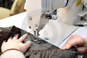 Shop for tailoring. A woman creates clothes on a sewing machine. Fashion industry for people. Stylish fashionista woman