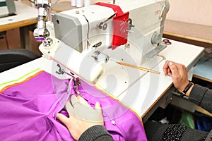 Shop for tailoring. A woman creates clothes on a sewing machine. Fashion industry for people. Stylish fashionista woman