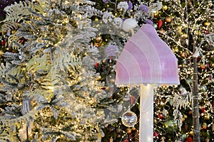 Shop window decoration, shopping center decor. artificial white spruce with garlands. beneath them is a mushroom with a large pink