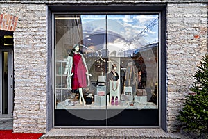 Shop window display with female winter clothing and accessories, Christmas decoration and sale.